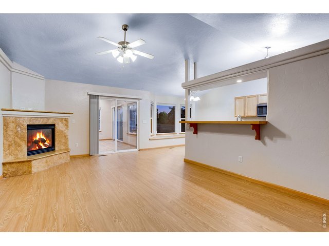 Property Photo 10 Open family room featuring vaulted ceilings, fan, corner gas fireplace with blower, travertine bench, backsplash and mantel