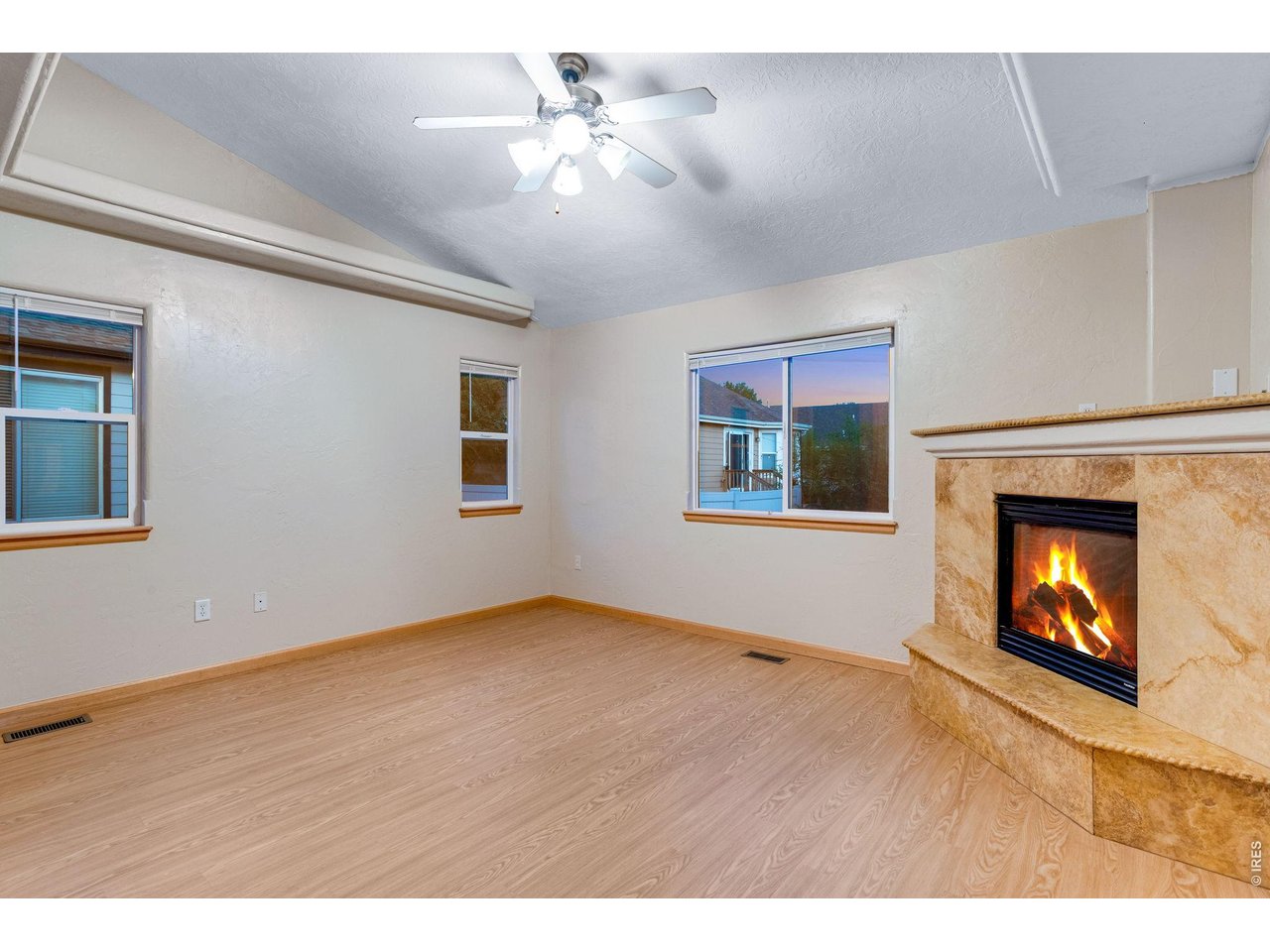 Property Photo 27 Primary bedroom with 2nd corner gas fireplace, vaulted ceiling, fan, private 5-piece luxury bath featuring a Bently walk-in tub with hand bar, shower with full travertine backsplash, walk-in closet, plus new carpet and padding