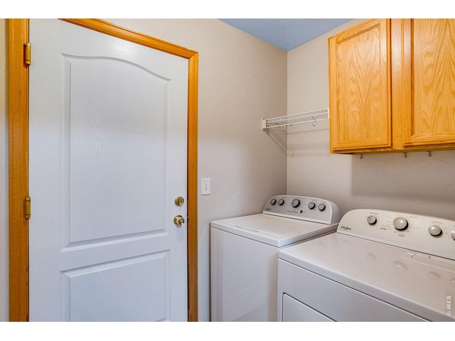 Property Photo 33 Main floor laundry features cabinets, kitchen pantry, shelf and both washer and dryer which are included