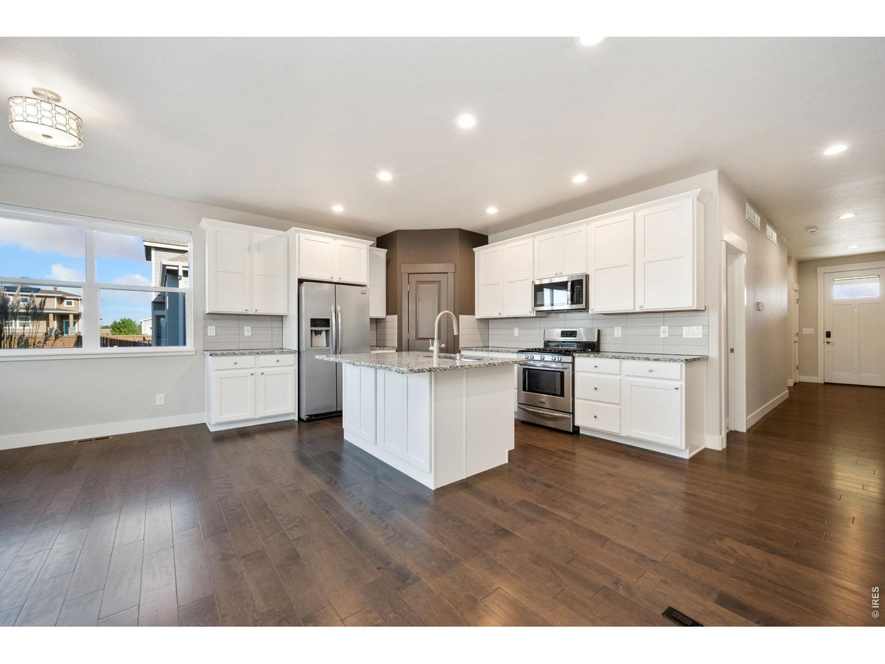 Property Photo 9 Kitchen with stainless steel appliances and white cabinets.