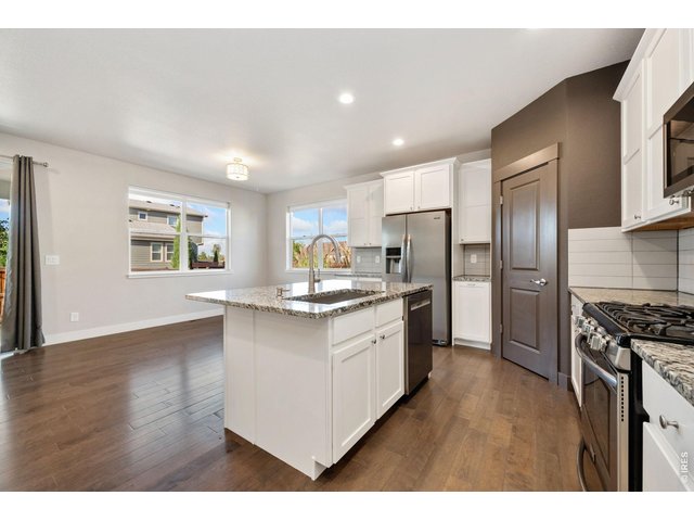 Property Photo 7 Open concept kitchen with pantry, lots of cabinet space and gas stove.