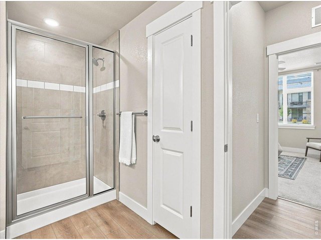 Property Photo 25 Walk-in shower fully tiled with a shower seat, plus linen closet