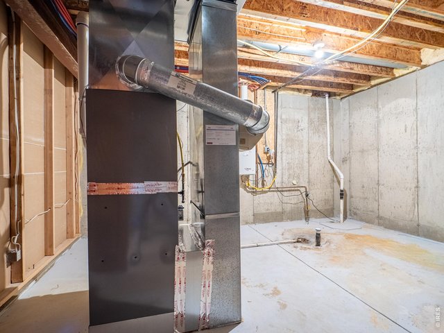 Property Photo 48 Utility room with tankless water heater, furnace, whole house humidifier, and radon mitigation system. Plenty of space for storage.