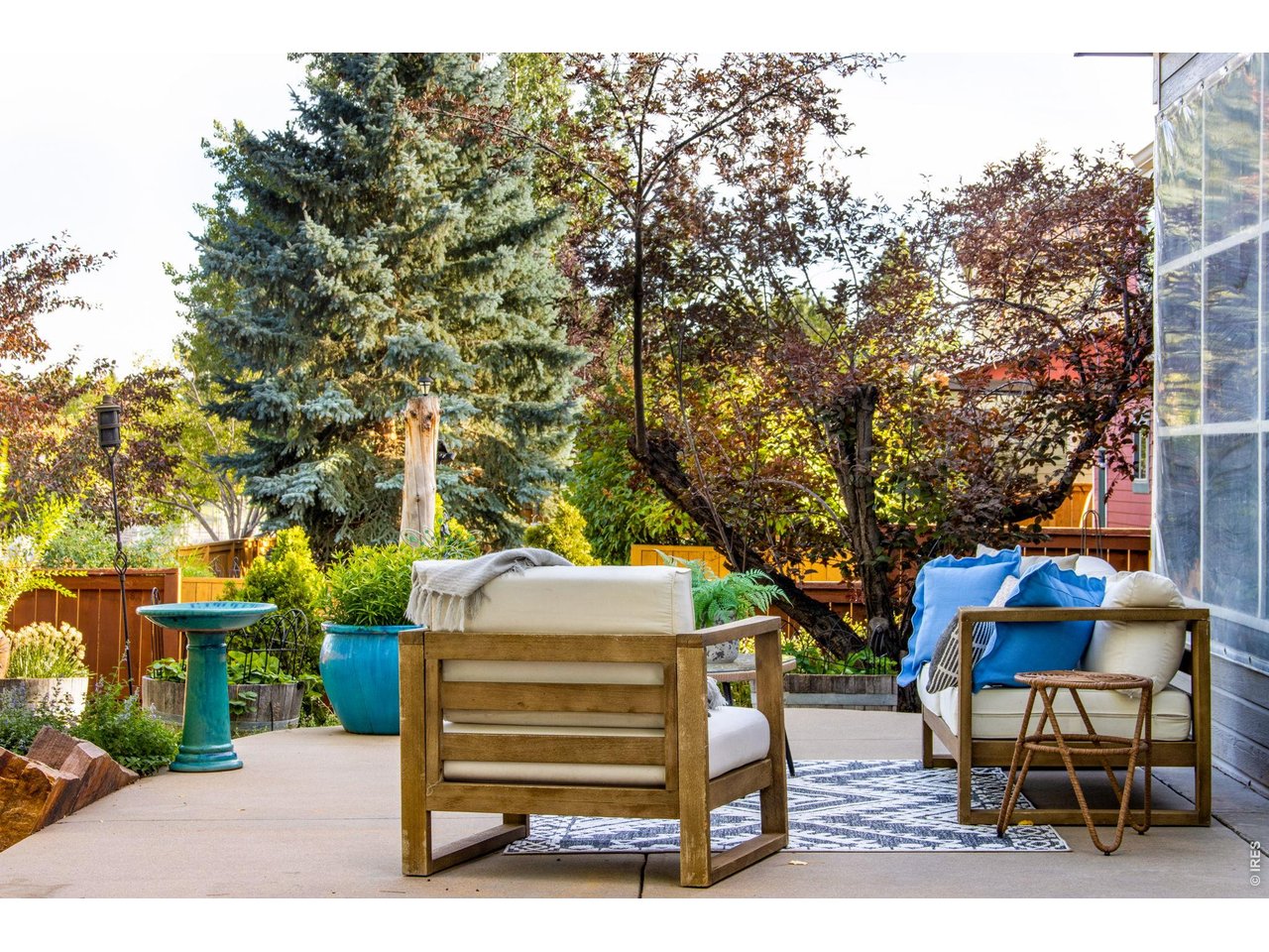 Property Photo 8 Tucked on the west side of the patio - serene Sunroom or covered and enclosed back patio! Gorgeous Established trees and perennials!
