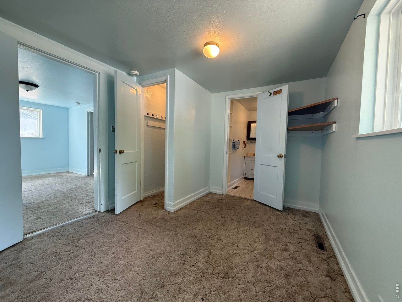 Property Photo 12 Primary Bedroom featuring a walk-in closet and en suite bathroom, conveniently located adjacent to the dining room.