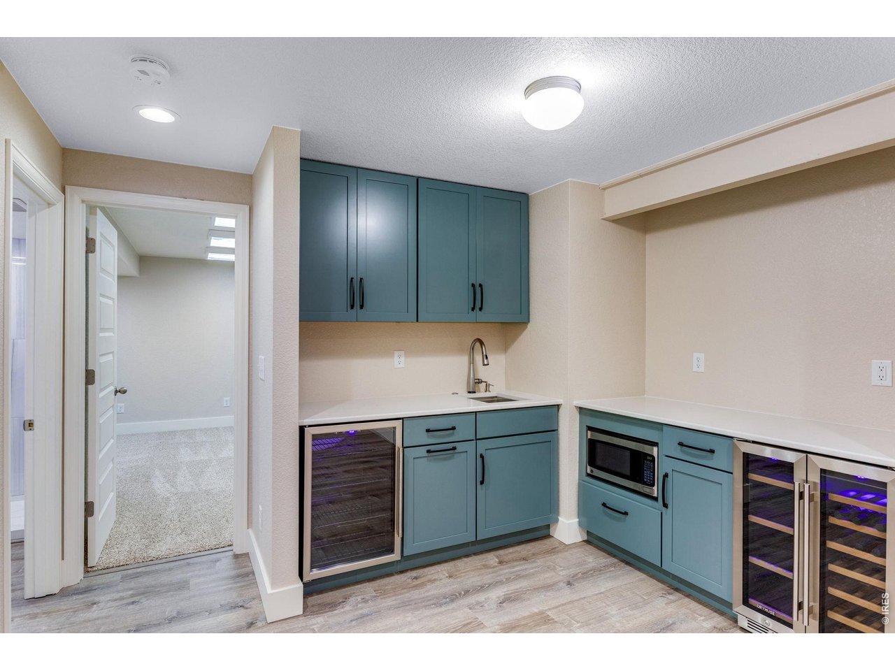 Property Photo 37 Wet bar with quartz countertop, garbage disposal, touchless faucet, wine cooler, microwave and refrigerate all included