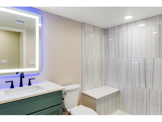 Property Photo 38 Under staircase storage bath features a full tile backsplash, lifted vanity, quartz countertop, and a comfort height toilet with soft close lid and a new glass door to shower (never used)