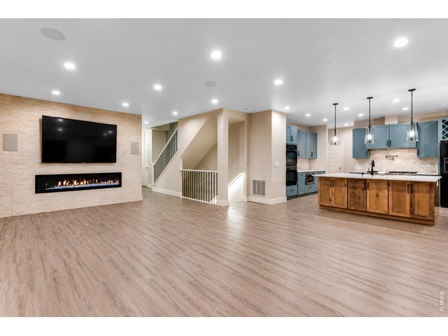 Property Photo 8 Open and bright family room with electric 240V double wide fireplace with floor to ceiling custom tile backsplash, top down bottom up shades, plenty of can lights and surround sound
