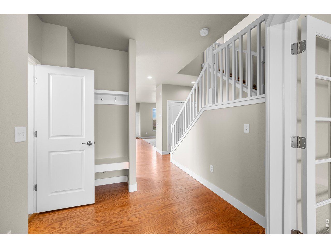 Property Photo 12 Entry Way with Coat Rack and Bench. Foyer and Kitchen Area have real hardwood flooring. Door to Main Floor Powder Bath.