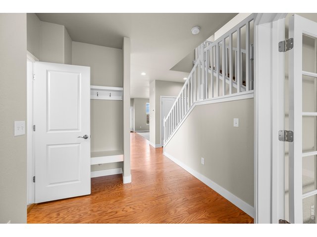 Property Photo 12 Entry Way with Coat Rack and Bench. Foyer and Kitchen Area have real hardwood flooring. Door to Main Floor Powder Bath.