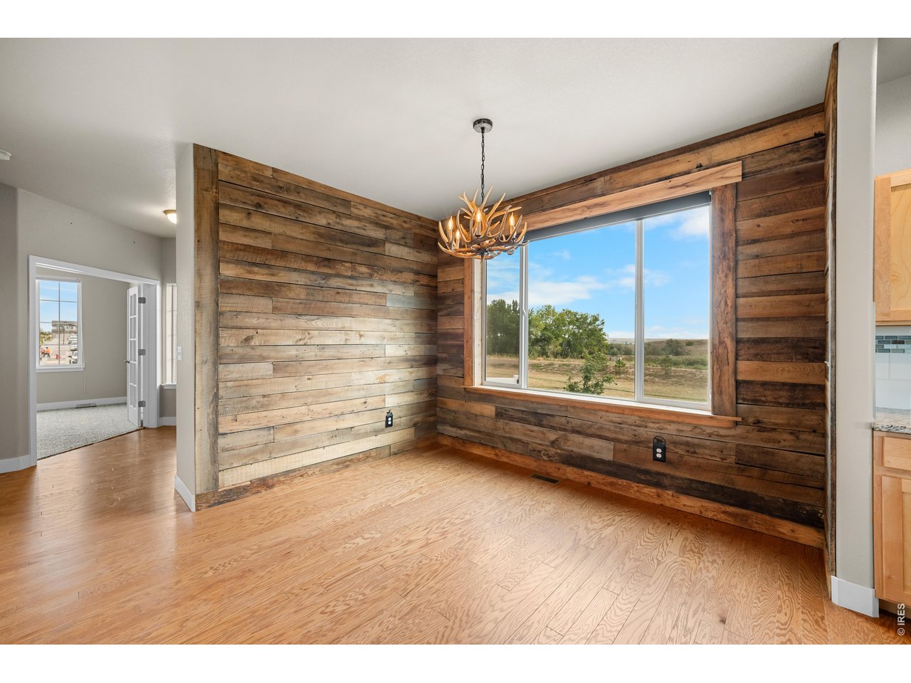 Property Photo 17 Custom Barn Wood on the Walls from an Old Loveland Barn dating back to the early 1900's. Antler Chandelier Included. Huge East Facing Window.