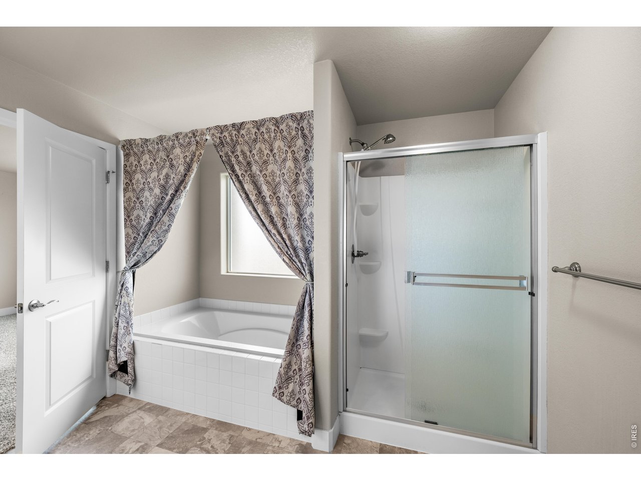 Property Photo 29 Primary Bathroom Oversized Soaking Tub with Large South Window and Walk-In Shower.