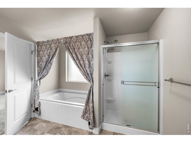 Property Photo 29 Primary Bathroom Oversized Soaking Tub with Large South Window and Walk-In Shower.