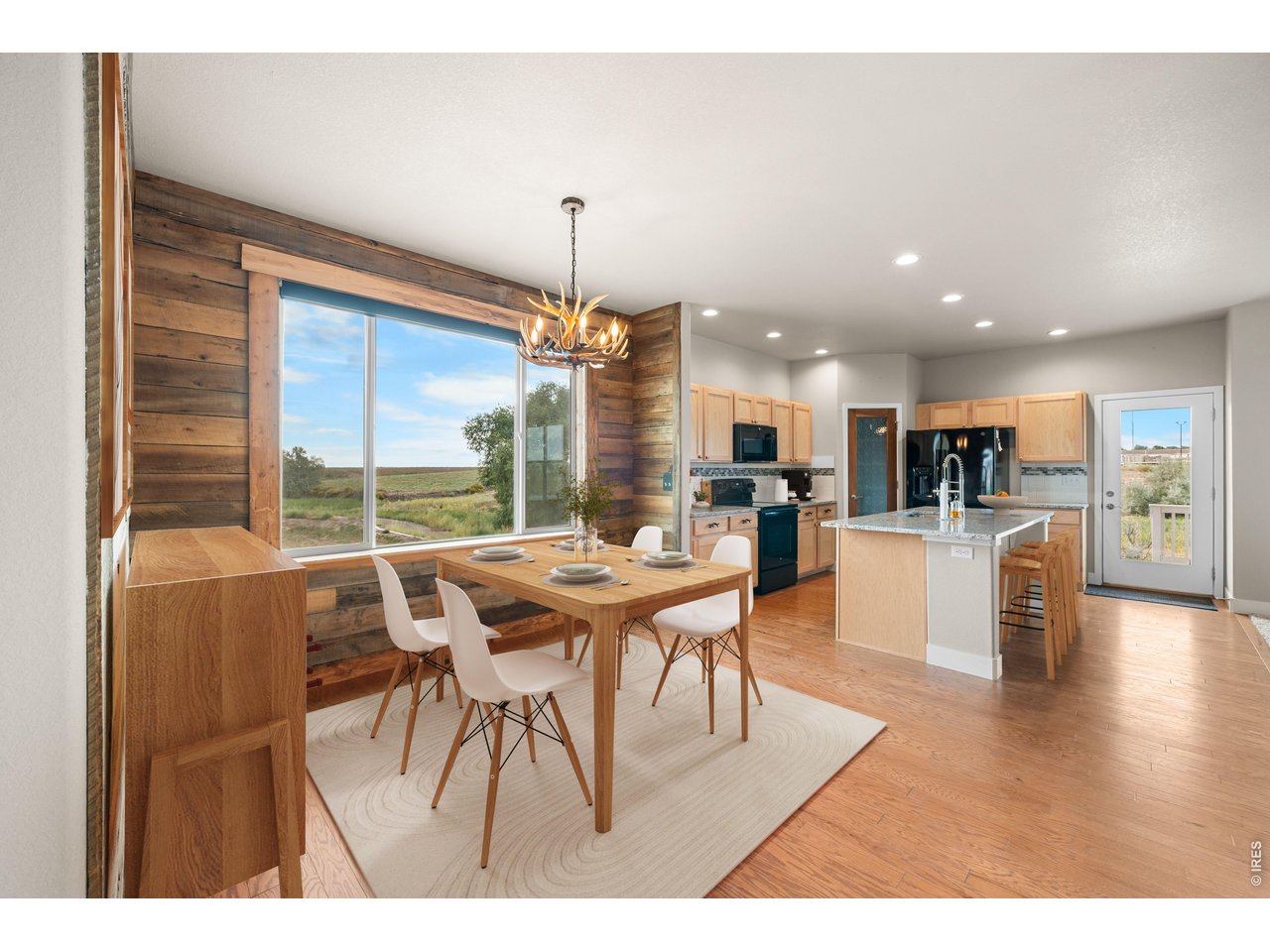 Property Photo 16 Spacious and Bright Dining and Kitchen with Back Patio Door to the Covered Deck. Virtually Staged Photo.