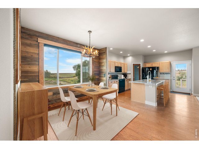 Property Photo 16 Spacious and Bright Dining and Kitchen with Back Patio Door to the Covered Deck. Virtually Staged Photo.