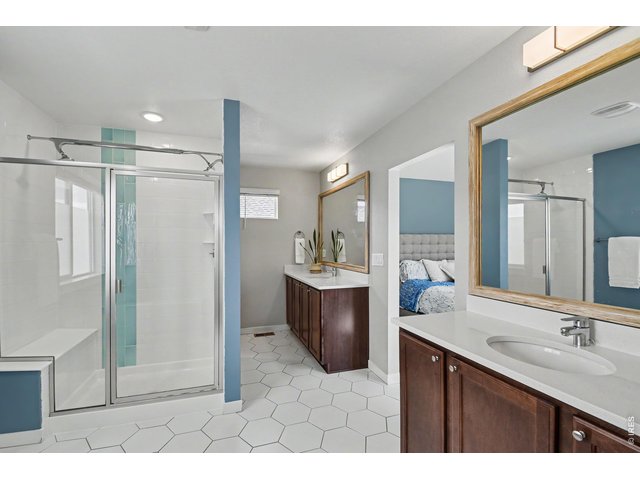 Property Photo 9 Spacious primary bathroom with 2 quartzite vanities, upgraded lighting, framed mirrors and double-headed shower.