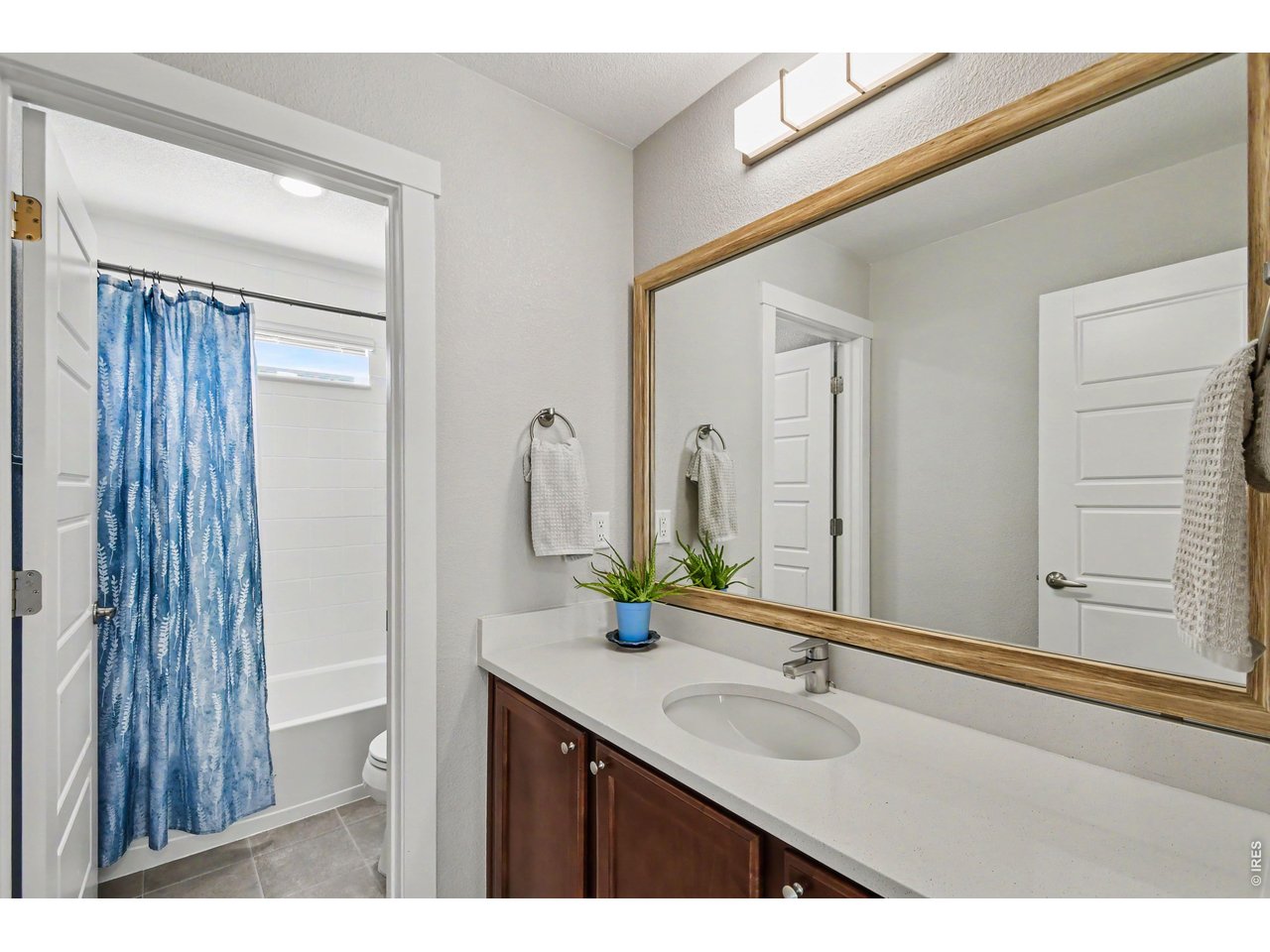 Property Photo 14 Shared upstairs bathroom with quartzite counters, framed mirror and upgraded lighting