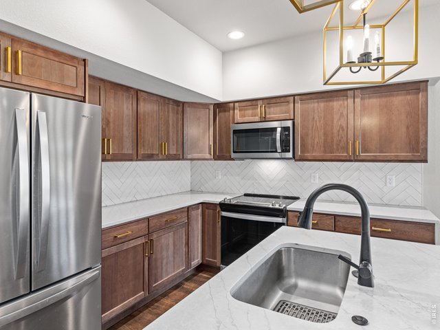 Property Photo 12 Stainless steel appliances and tile herringbone pattern backsplash