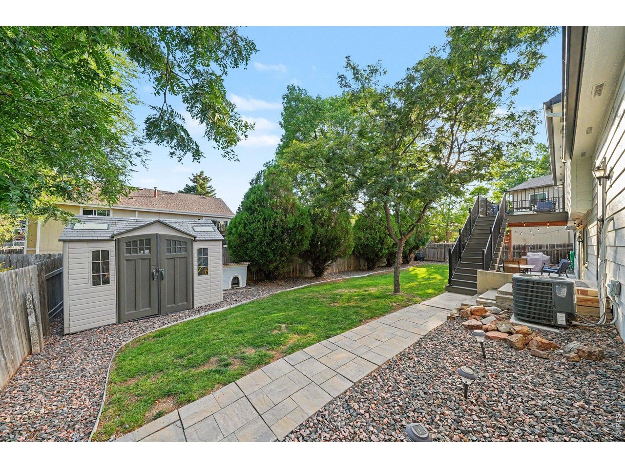 Property Photo 36 A spacious, neatly landscaped backyard complete with a paver walkway, lush lawn, and handy storage shed.