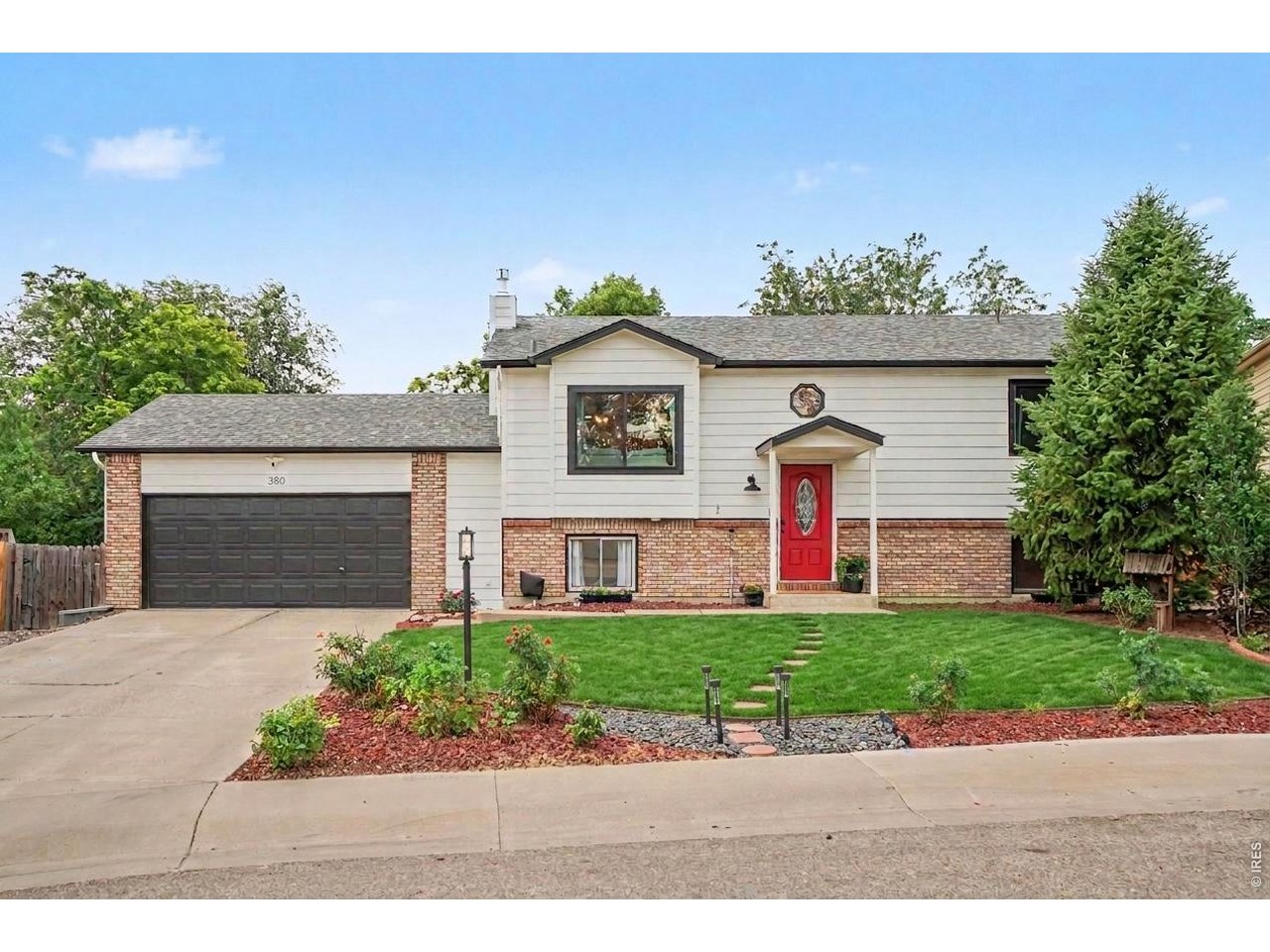 Property Photo 43 Beautifully maintained split-level with a modern facade, iconic red door, and a spacious two-car garage.