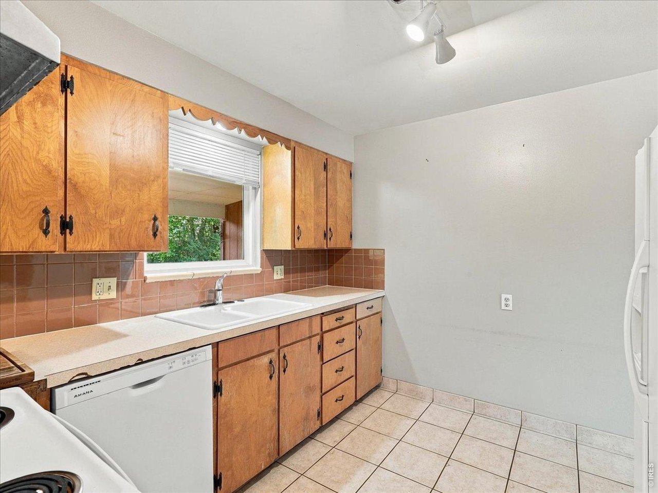 Property Photo 7 Kitchen with newer stove and dishwasher, vintage cabinets, title back splash