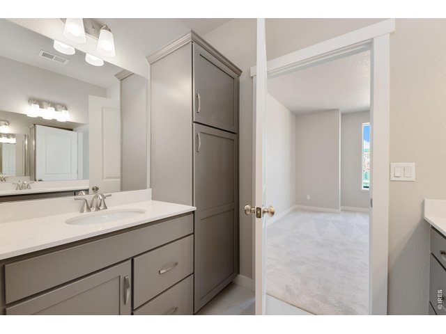 Property Photo 17 Primary bathroom with two separate vanities & a roomy cabinet tower for extra storage