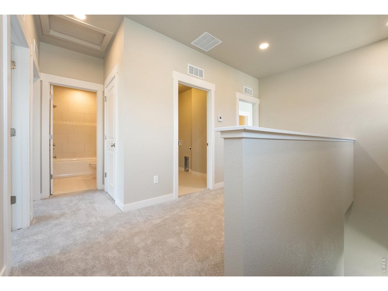 Property Photo 11 Upstairs loft area with shared laundry off the hallway. Finishes may vary.