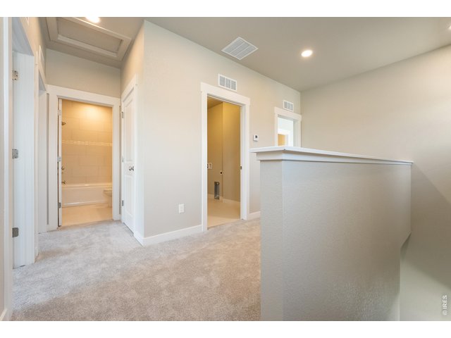 Property Photo 11 Upstairs loft area with shared laundry off the hallway. Finishes may vary.