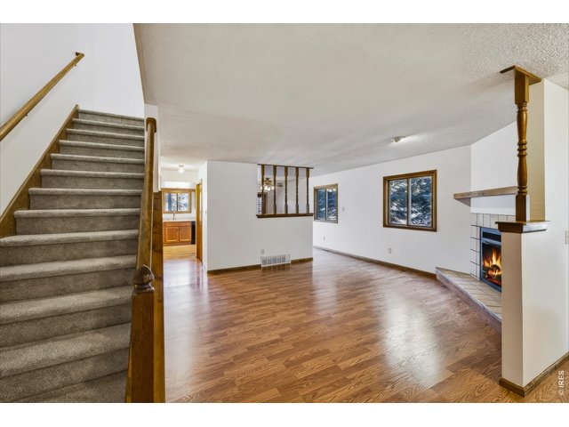 Property Photo 9 Spacious living room with wood-burning fireplace.