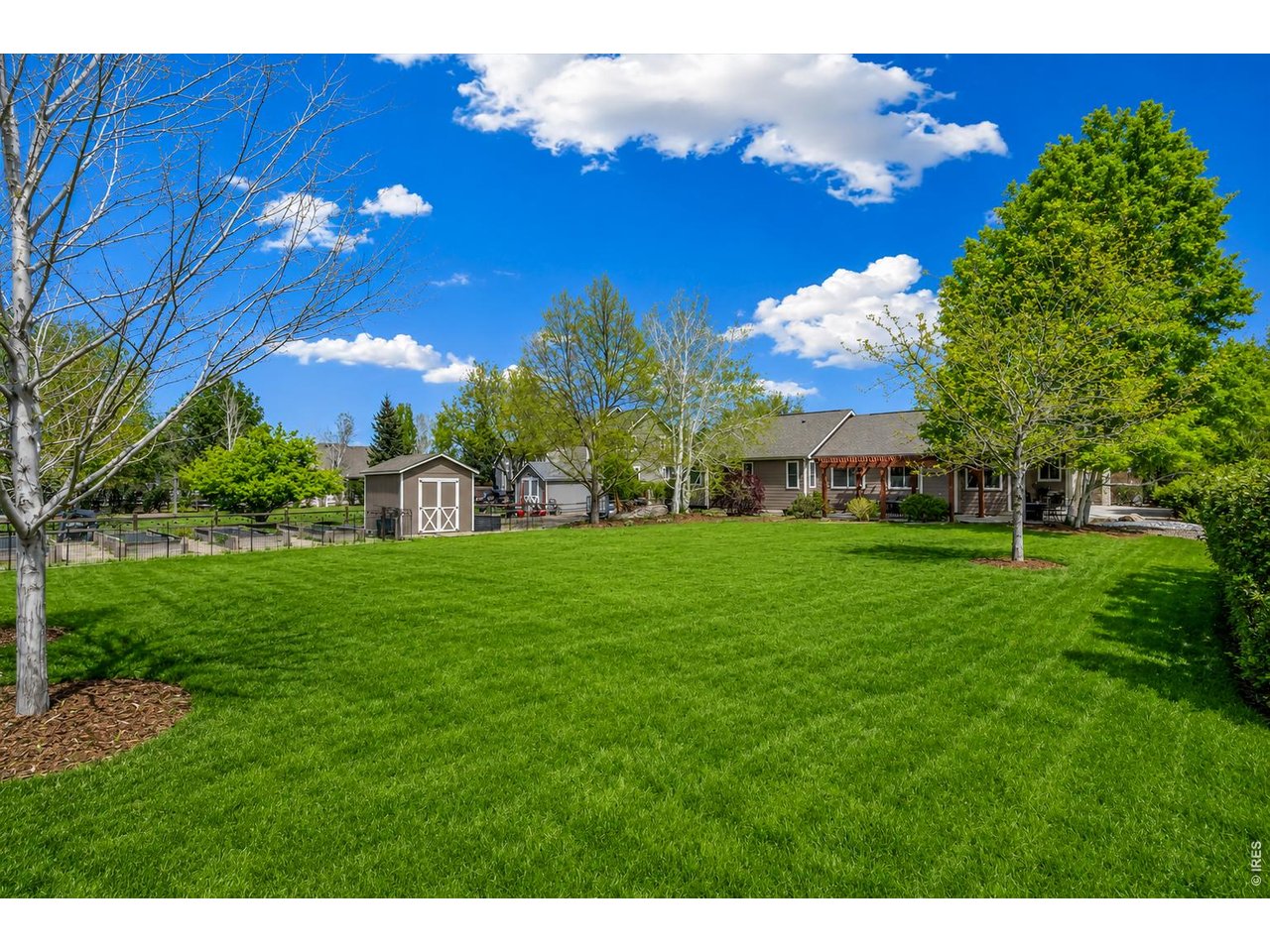 Property Photo 7 Large 1/2 acre backyard with 10 raised garden beds, a drip irrigation system, and a charming bungalow, making gardening easy and enjoyable