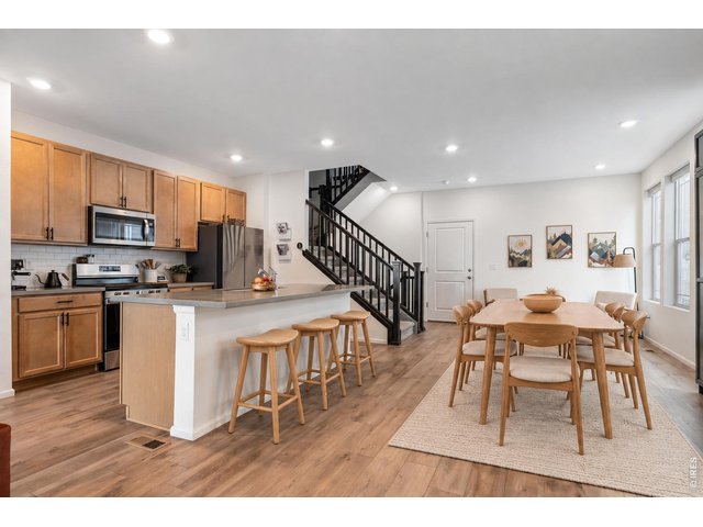Property Photo 1 Light-filled kitchen and dining space with soaring ceilings **Image virtually staged.
