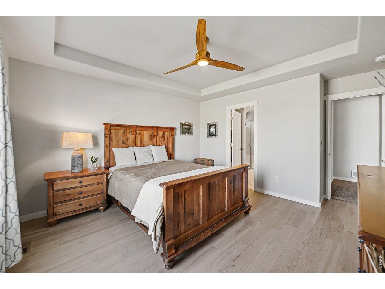Property Photo 10 Primary bedroom with coffered ceiling and trendy ceiling fan.
