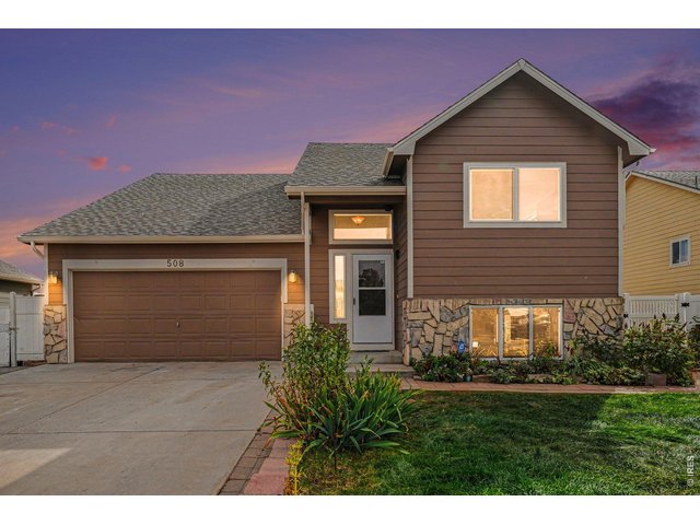 Property Photo 2 Front Elevation with Stone Accent sand 2-car garage.
