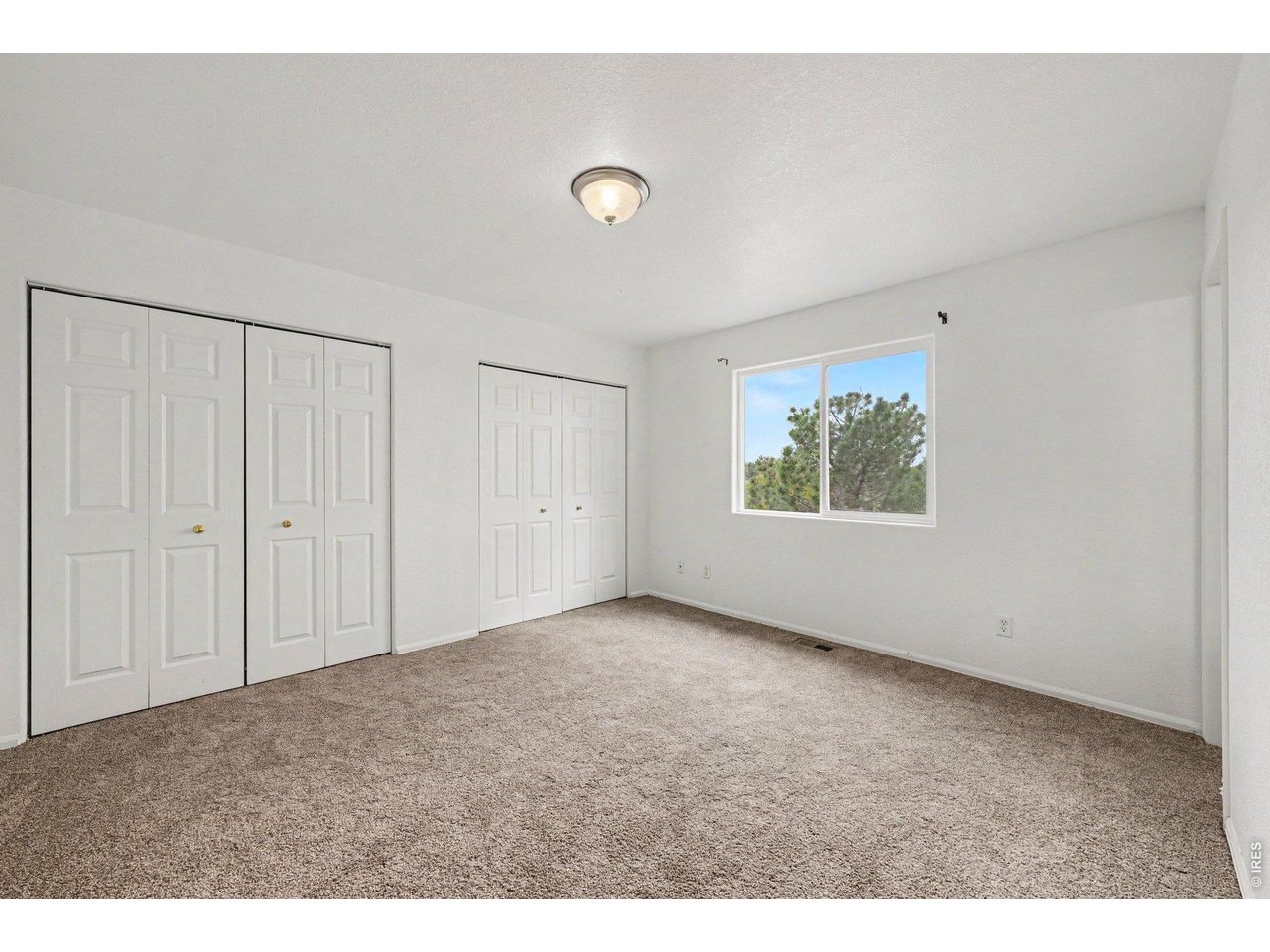 Property Photo 12 Primary Bedroom with natural light and spacious closet.