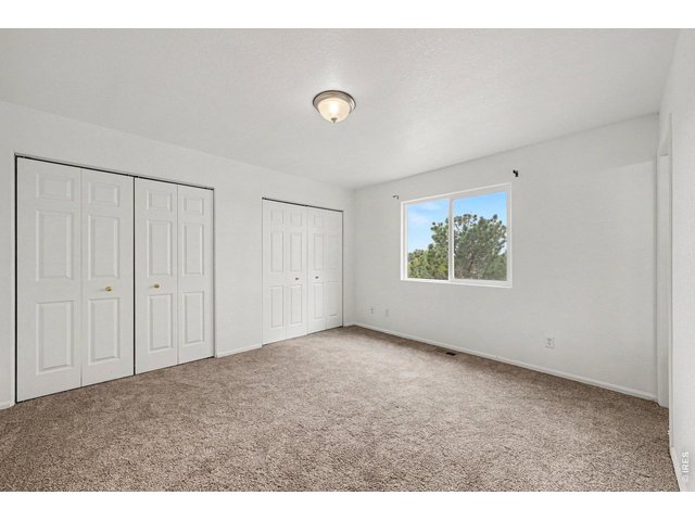 Property Photo 12 Primary Bedroom with natural light and spacious closet.