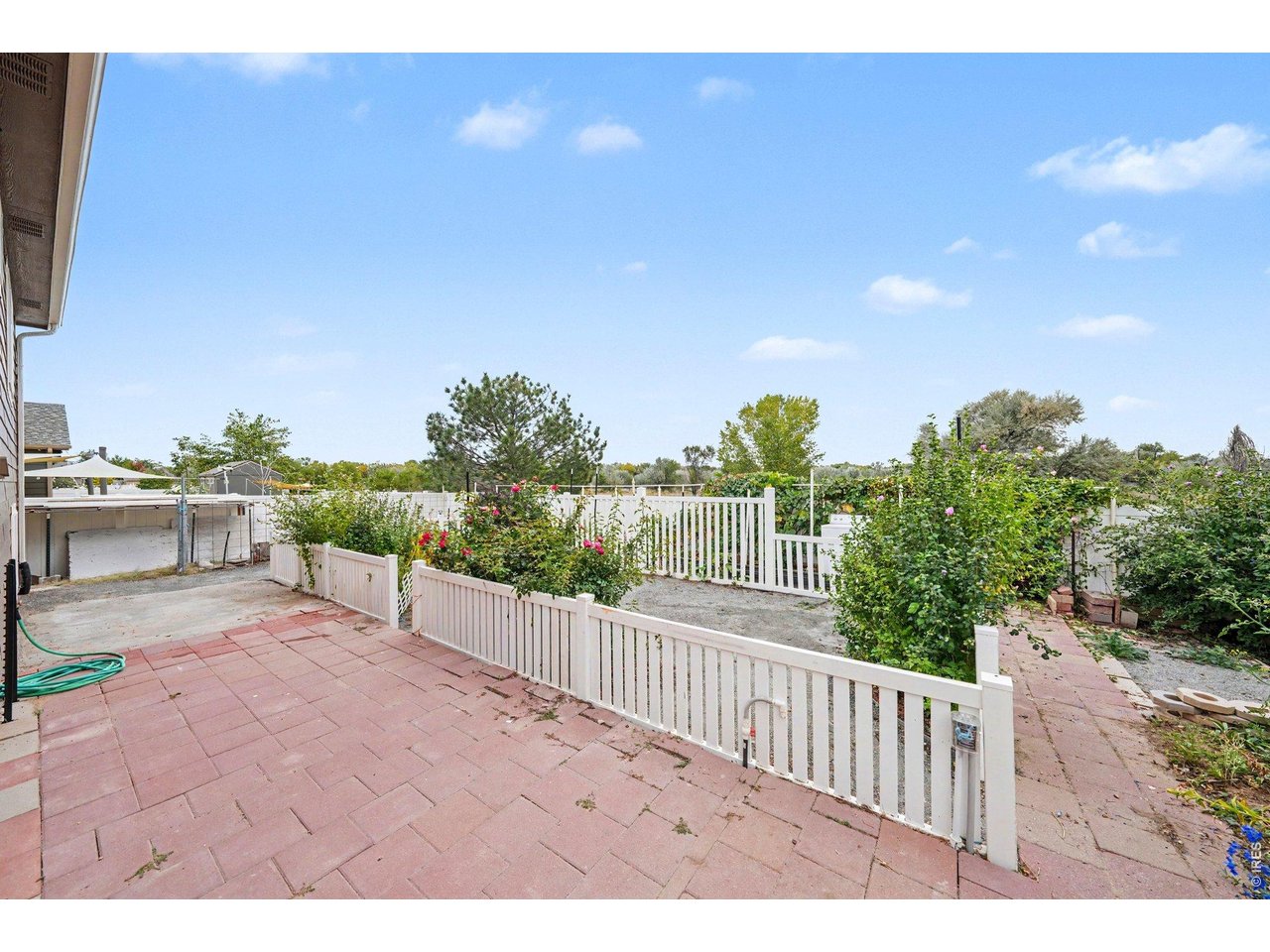 Property Photo 22 Beautifully landscaped backyard featuring vibrant flowers and a serene outdoor space.
