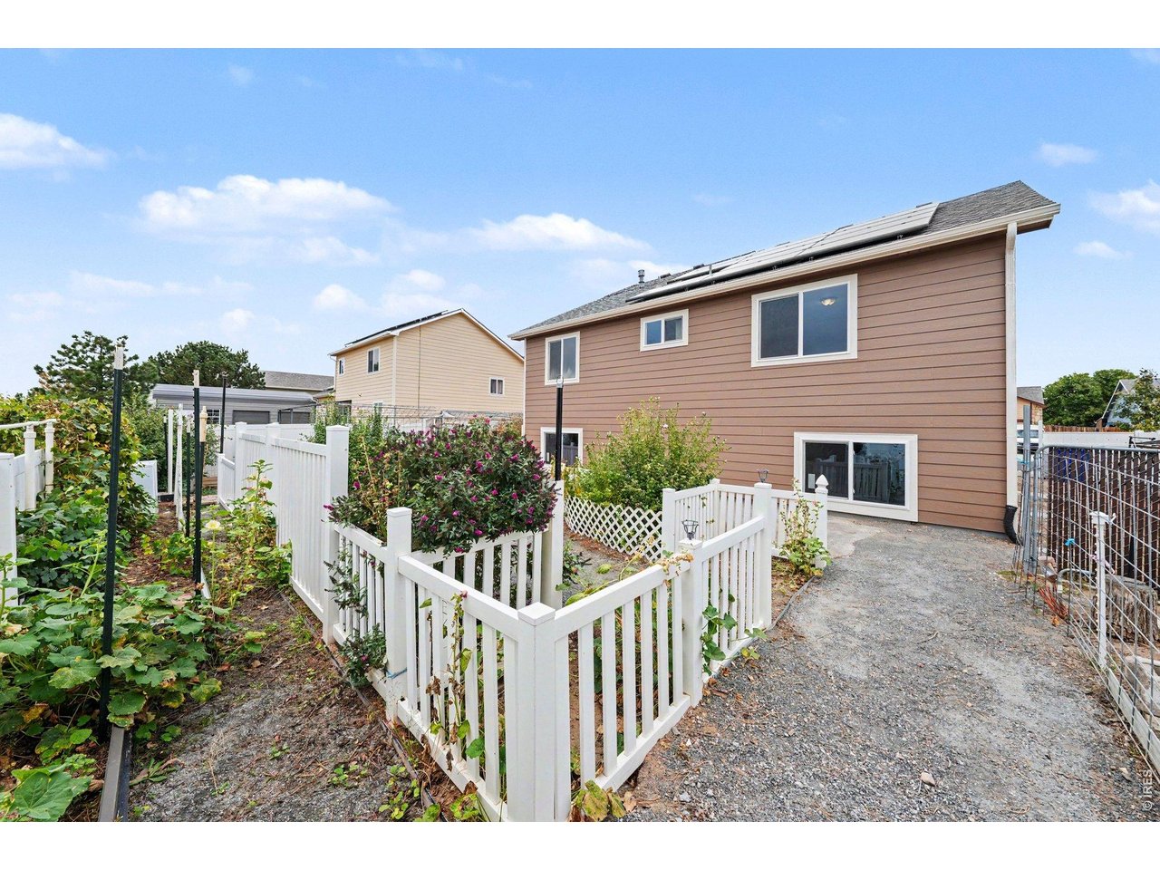 Property Photo 23 Fenced Backyard with Gravel Parking Pad and Garden Beds