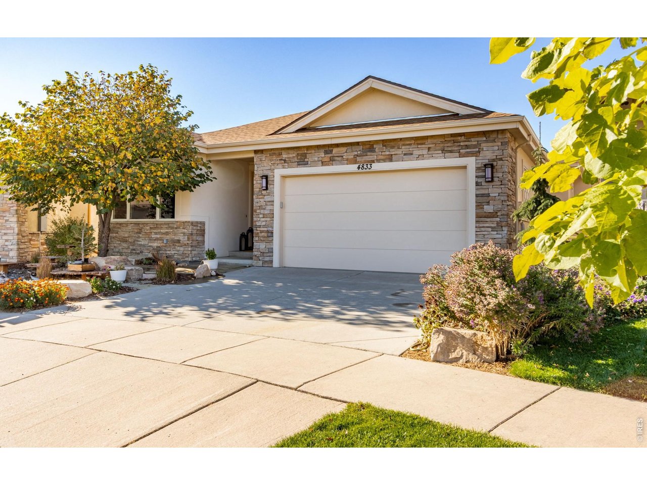 Property Photo 4 Welcome, beautiful flagstone entry and comfortable covered front porch and a beautiful RedBud tree to greet you!  Low Maintenance Stone and Stucco exterior.  Idyllic for the Colorado Outdoor Enthusiast!  Triple Glaze Andersen Windows!