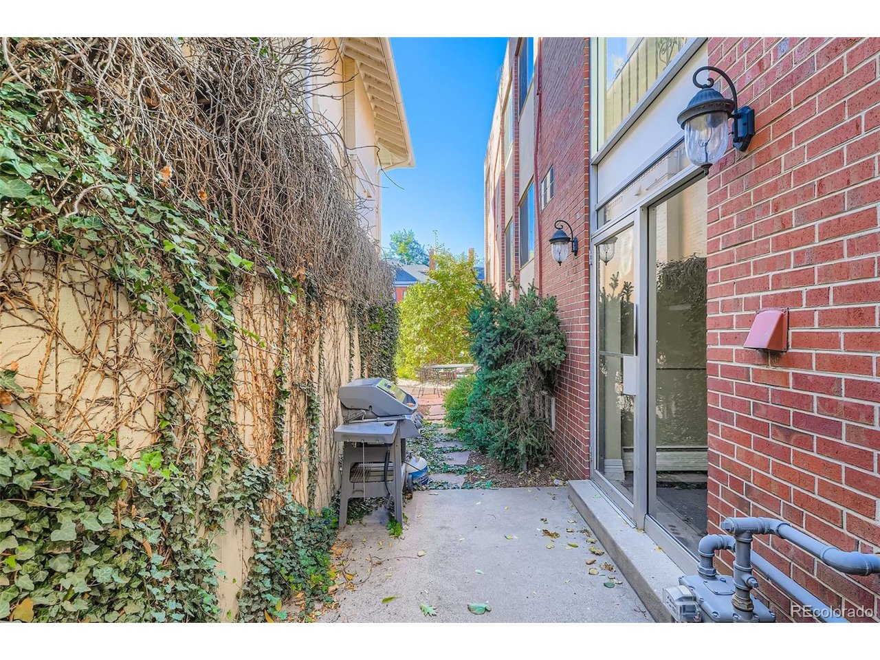 Garden spot with a BBQ grill with patio and chairs.