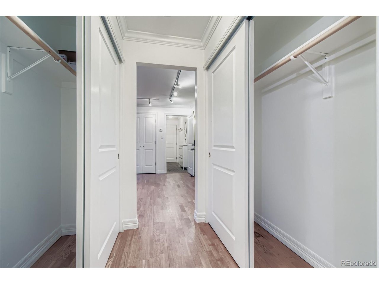 Hallway from the bathroom with a view of the closets open.