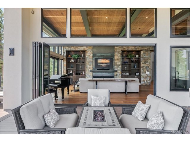 Property Photo 10 A covered outdoor deck extends the living space, providing an ideal setting to relax, entertain, and enjoy the surrounding scenery in comfort year-round