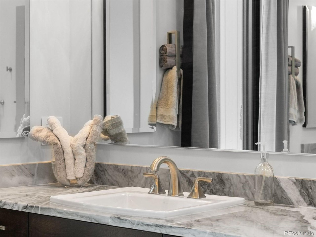 The primary bathroom is stunning, featuring modern finishes, a spa-like atmosphere, and thoughtful details throughout