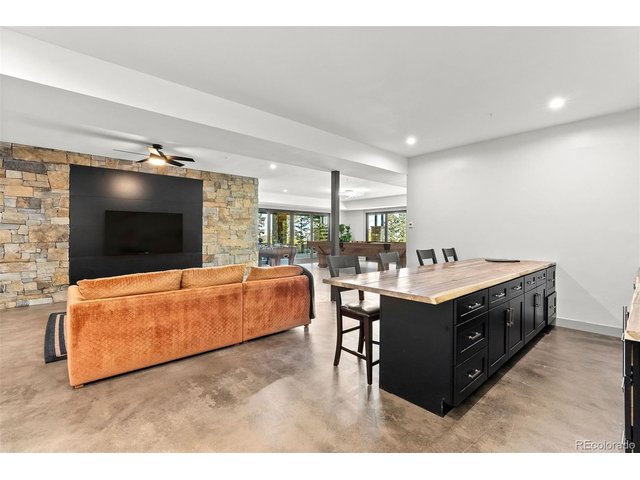 Property Photo 47 A spacious lower-level room is designed for entertaining, featuring a full bar, room for games, and multiple seating zones