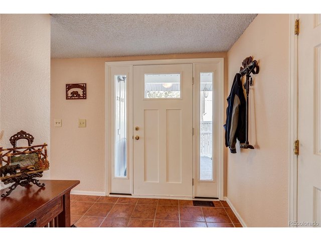 Property Photo 5 Looking northeast, new front door and side panel windows. Please note the lovely newer tile floor that serves the entry area as well as the kitchen.