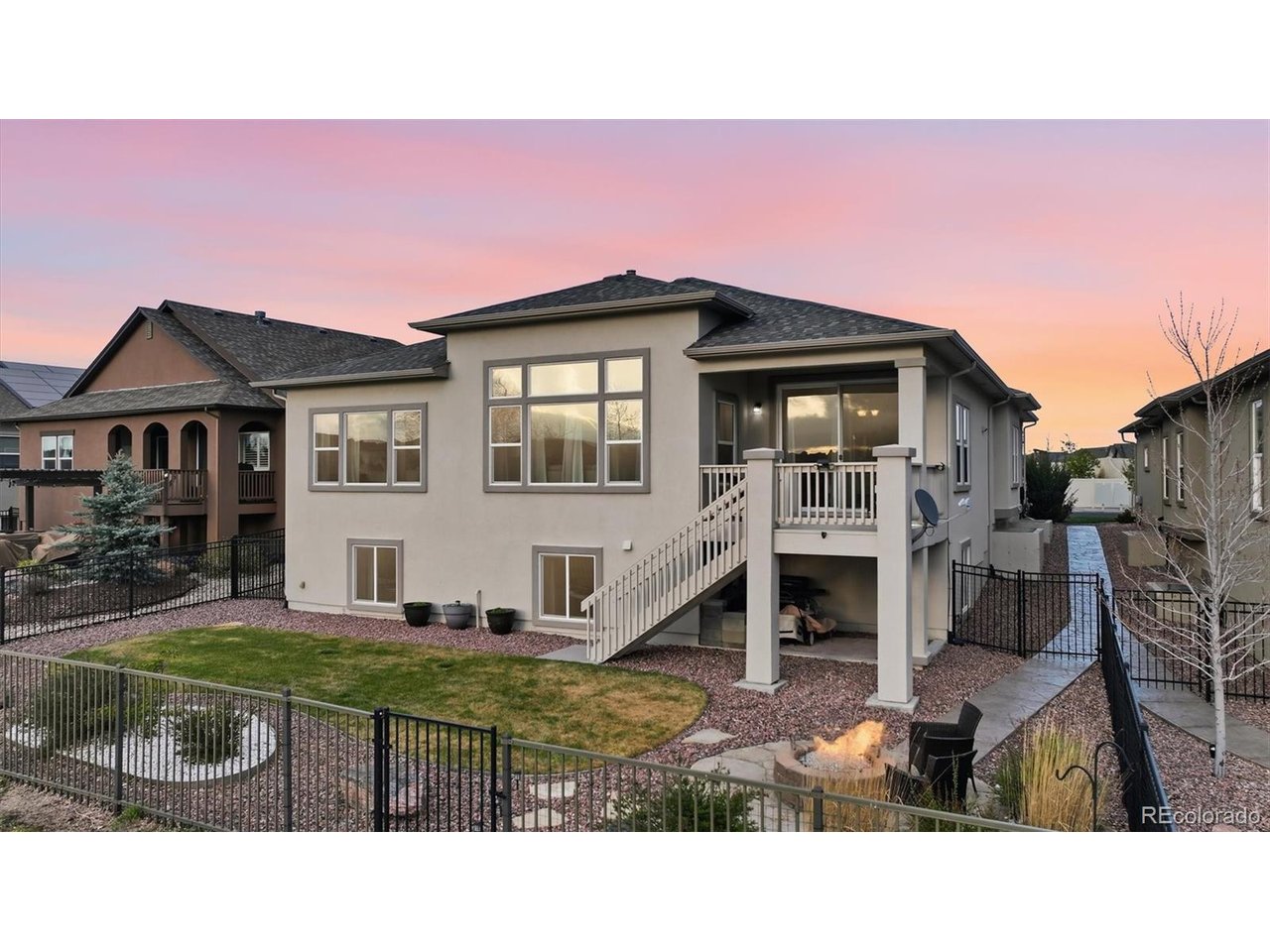 Rear view of home and fenced backyard.