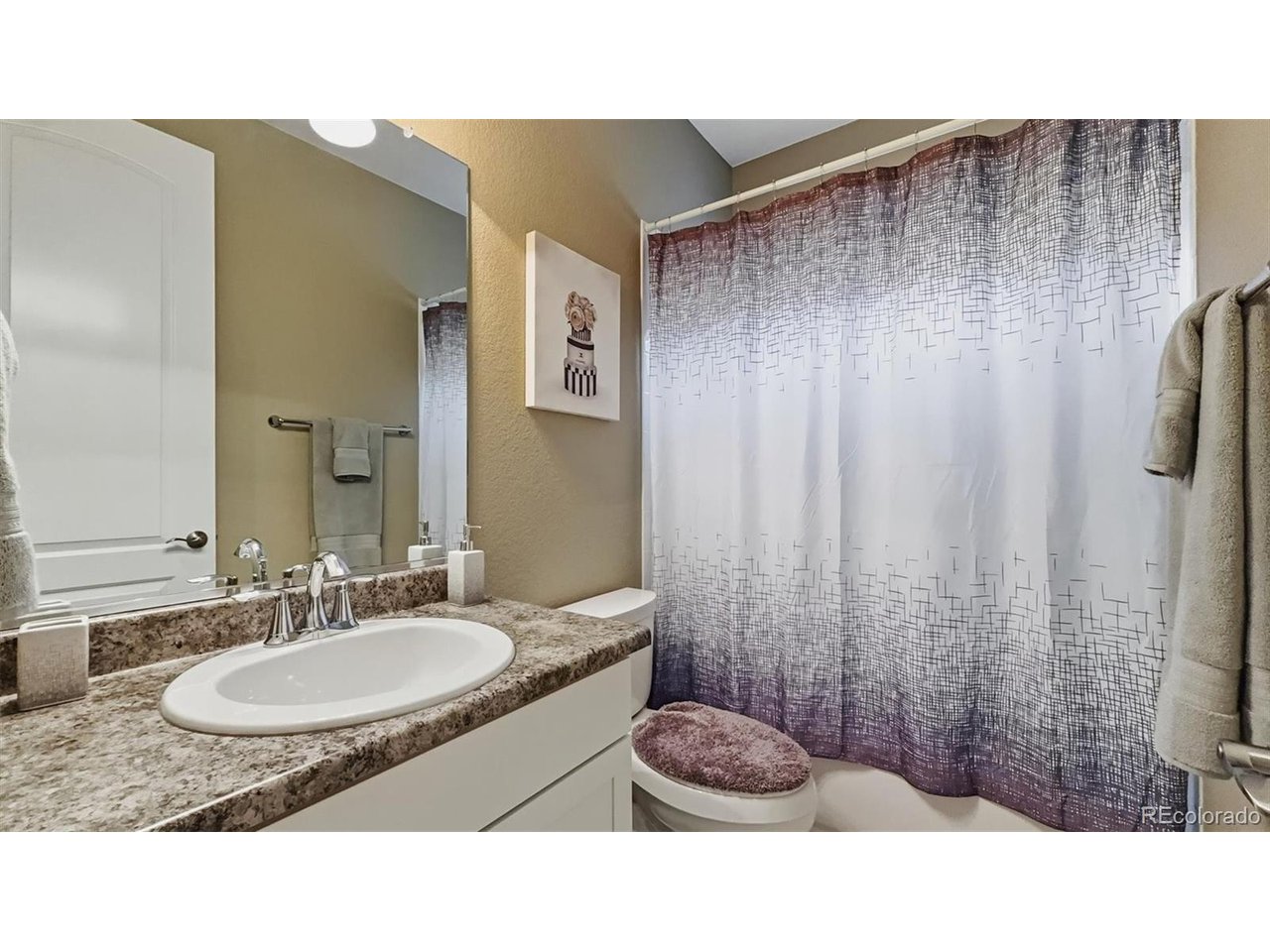 Main Level Full Bathroom with vanity, mirror, and tiled tub/shower.