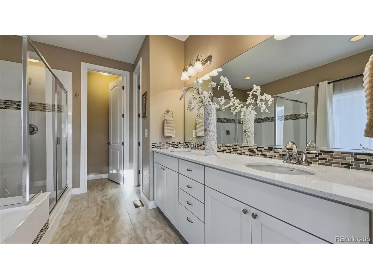 The Primary Bathroom features a dual sink vanity, mirror, jetted tub, and separate tiled shower.