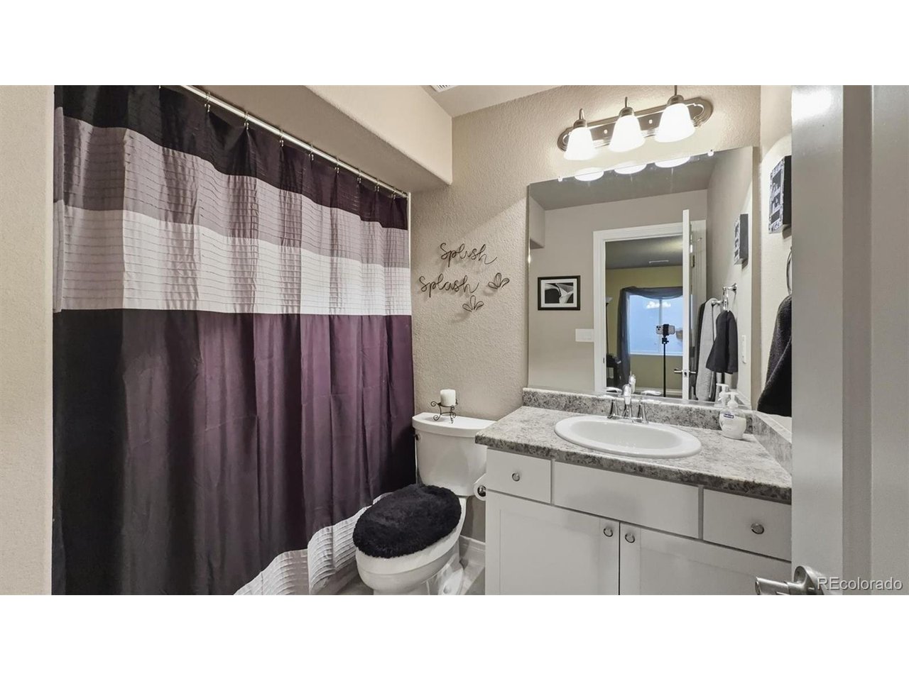Full Bathroom located off the Bedroom Suite with vanity, mirror, and tiled tub/shower.