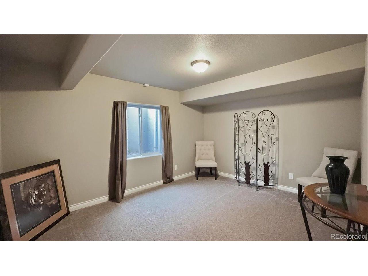 Basement Bedroom #5 with neutral carpet and walk in closet.