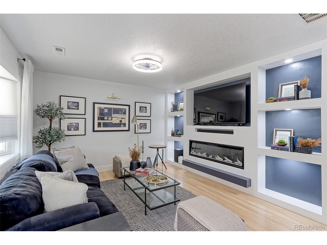This 16x12 living room has beautiful solid Oak floors, designer lighting and a large bay wall of thermal pane windows with custom no cord, light filtering up and down solar shades.